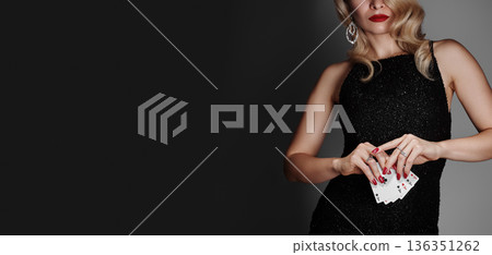 Blonde lady woman in black shiny dress and expensive diamond jewelry is winner money from Omaha Holdem. She is smiling, showing Aces cards to the camera. Ideal style for Poker, Casino, Gambling Blonde lady woman in black shiny dress and expensive diamond jewelry is winner money from Omaha Holdem. She is smiling, showing Aces cards to the camera. Ideal style for Poker, Casino, Gambling 136351262