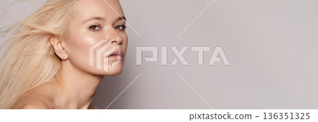 Freshfaced Woman With Soft Aura. Pure And Luminous Complexion Complemented By Subtle Makeup Look. Natural looking Woman With Dewy Skin Exudes Calmness And Understated Elegance In Studio Setting 136351325