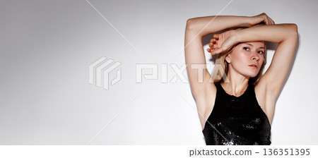 Beauty Fashion Woman Posing Arms Raised, Black Sequin Dress, Confident Performance Vibe, Strong Posture, Directional Lighting, Minimalist White Background, Edgy Editorial Styling, Expressive Beauty Fashion Woman Posing Arms Raised, Black Sequin Dress, Confident Performance Vibe, Strong Posture, Directional Lighting, Minimalist White Background, Edgy Editorial Styling, Expressive 136351395