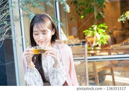 A young woman drinking tea on the terrace of a cafe 136351517