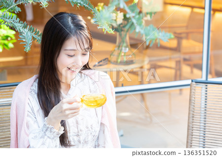 A young woman drinking tea on the terrace of a cafe 136351520