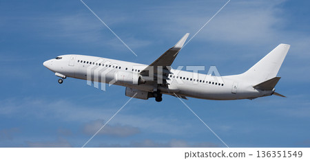 Airplane take off on the blue sky, with white clouds. Aircraft flying on sky background. White passenger jet plane in the blue sky. Low angle view of Airplane flying under blue sky, with white clouds Airplane take off on the blue sky, with white clouds. Aircraft flying on sky background. White passenger jet plane in the blue sky. Low angle view of Airplane flying under blue sky, with white clouds 136351549