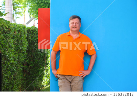 Portrait of an adult blond man against the blue wall of his house Portrait of an adult blond man against the blue wall of his house 136352012