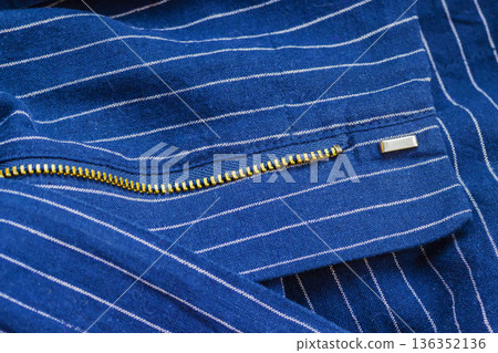 Blue Fabric With Zipper. Close up of fabric with golden metal zipper, garment construction detail, apparel production. Natural background of fabric texture of fashion design sewing process manufacture 136352136