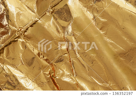 Crumpled gold foil texture with shiny metallic surface, rich reflective details filling entire frame. Luxury gold backdrop, premium gold background, abstract design for mockup 136352197