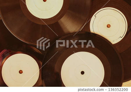 Vintage vinyl records background. Close-up of old vinyl records with labels arranged in overlapping composition. Concept of retro music, analog sound, vintage record collection, music archive 136352200