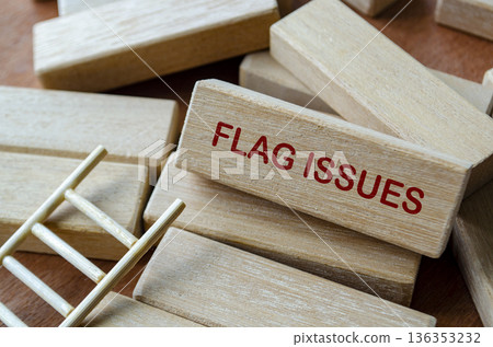 FLAG ISSUES text on wooden blocks highlighting early risk identification and compliance awareness. 136353232