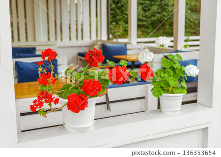 Outdoor cafe terrace with colorful decorative flowers in pots, cozy summer restaurant seating area Outdoor cafe terrace with colorful decorative flowers in pots, cozy summer restaurant seating area 136353654