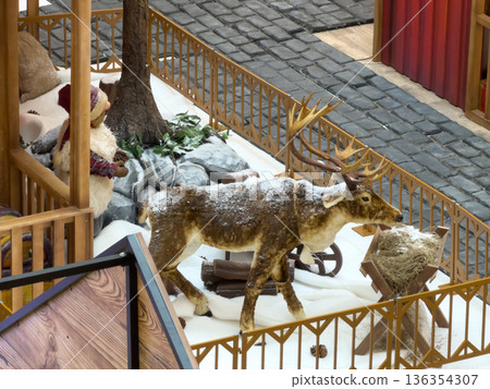 Festive reindeer and elf figures in a snowy village scene, creating a charming winter holiday display perfect for seasonal marketing and celebrations Festive reindeer and elf figures in a snowy village scene, creating a charming winter holiday display perfect for seasonal marketing and celebrations 136354307