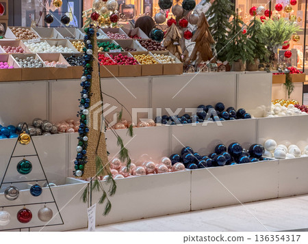 Vibrant Christmas ornaments and diverse holiday decorations are attractively displayed in a retail store, inviting shoppers to prepare for festive seasonal celebrations Vibrant Christmas ornaments and diverse holiday decorations are attractively displayed in a retail store, inviting shoppers to prepare for festive seasonal celebrations 136354317