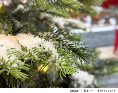 Lush green fir tree branch covered in fresh white snow, sparkling festive lights evoking magical holiday season, cozy winter wonderland, and joyful atmosphere Lush green fir tree branch covered in fresh white snow, sparkling festive lights evoking magical holiday season, cozy winter wonderland, and joyful atmosphere 136354321