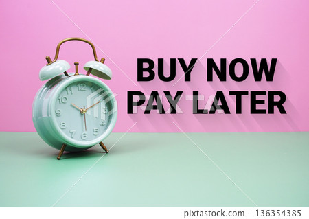 Black alarm clock on a pastel green and pink background with the text "Buy Now Pay Later" Black alarm clock on a pastel green and pink background with the text "Buy Now Pay Later" 136354385