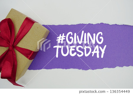 Giving Tuesday text with gift box present on purple background Giving Tuesday text with gift box present on purple background 136354449