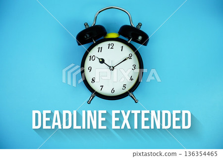 Deadline Extended text and alarm clock on blue background 136354465