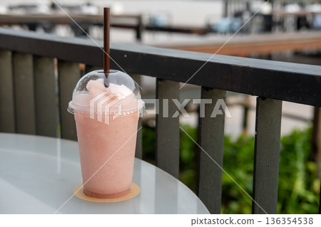 A cup of blended lychee on the table, with bokeh background of the river A cup of blended lychee on the table, with bokeh background of the river 136354538