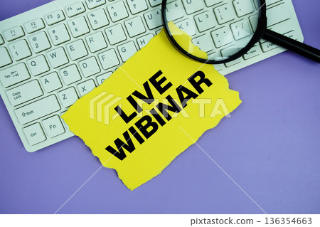Yellow paper with text "Live Webinar" and magnifying glass placed on a white keyboard Yellow paper with text "Live Webinar" and magnifying glass placed on a white keyboard 136354663