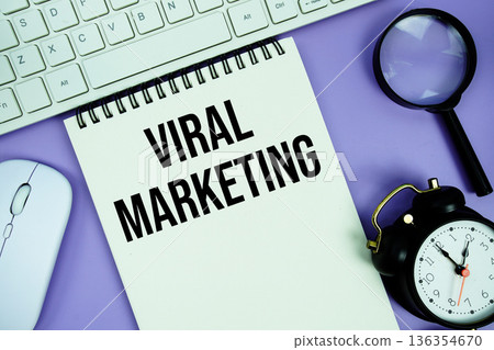 Notepad with the text "Viral Marketing" and white keyboard, wireless mouse, magnifying glass and alarm clock Notepad with the text "Viral Marketing" and white keyboard, wireless mouse, magnifying glass and alarm clock 136354670
