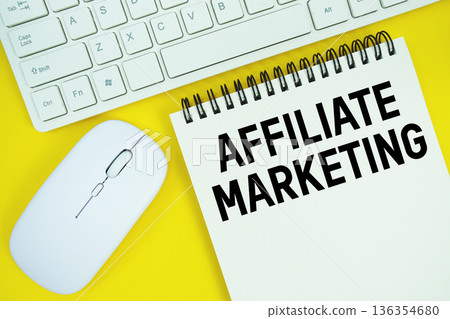 Notepad with the text "Affiliate Marketing" with white keyboard and wireless mouse on yellow background Notepad with the text "Affiliate Marketing" with white keyboard and wireless mouse on yellow background 136354680