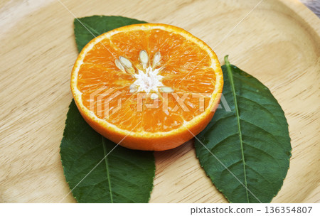 Orange cut in half on wooden background 136354807