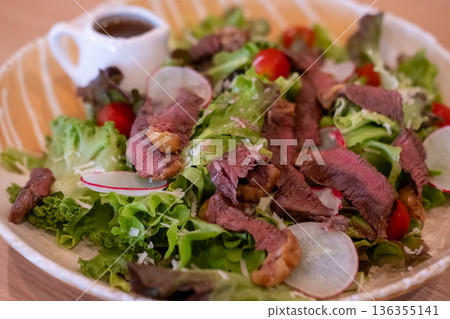 Salad with sliced medium rare meat served on plate Salad with sliced medium rare meat served on plate 136355141