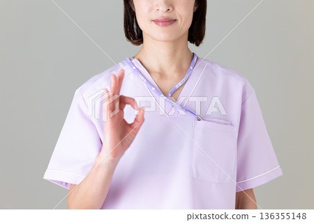 A middle-aged female nurse in a medical scrub 136355148