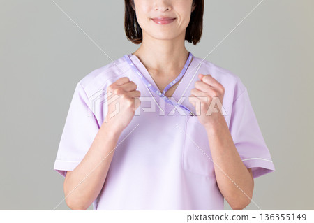 A middle-aged female nurse in a medical scrub 136355149