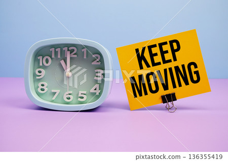 Keep Moving text and alarm clock on blue and purple background 136355419