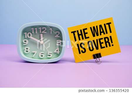 The Wait Is Over! text and alarm clock on blue and purple background 136355420