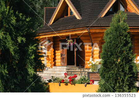 Traditional wooden log house with flowers and open door in mountain village Traditional wooden log house with flowers and open door in mountain village 136355523