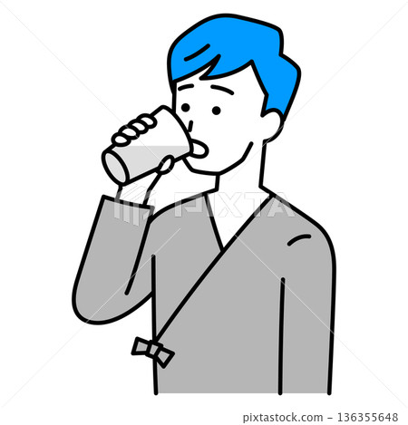 A young man in examination clothes drinking barium A young man in examination clothes drinking barium 136355648