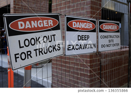 A signboard (construction site) with a row of danger signs in English indicating no trespassing A signboard (construction site) with a row of danger signs in English indicating no trespassing 136355866