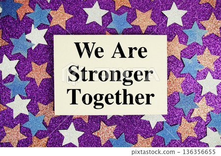 "We Are Stronger Together" quotes on paper card with purple glitter background with white, pink and blue stars 136356655