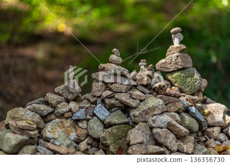 Stone cairns stacked on rocky mound in forest Stone cairns stacked on rocky mound in forest 136356730