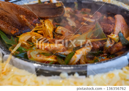 Spicy korean stir-fry with rice cakes and vegetables in hot pan 136356762
