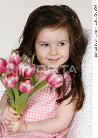 Little girl with bouquet of pink tulips Little girl with bouquet of pink tulips 136356954