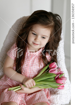 Little girl with bouquet of pink tulips Little girl with bouquet of pink tulips 136356957