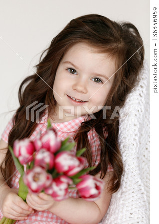Little girl with bouquet of pink tulips Little girl with bouquet of pink tulips 136356959