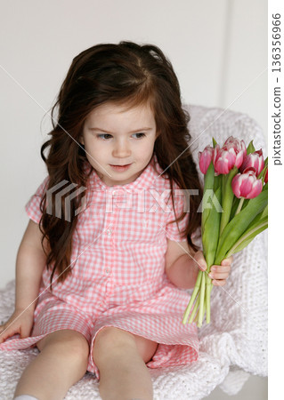 Little girl with bouquet of pink tulips Little girl with bouquet of pink tulips 136356966