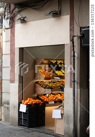 Fruit and vegetable storefront displaying fresh oranges, lemons, kiwi, and other produce in crates, representing local retail and healthy food options 136357228