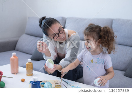 Mother and daughter painting Easter eggs 136357889