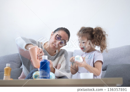 Mother and daughter painting Easter eggs Mother and daughter painting Easter eggs 136357891