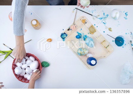 Mother and daughter painting Easter eggs 136357896