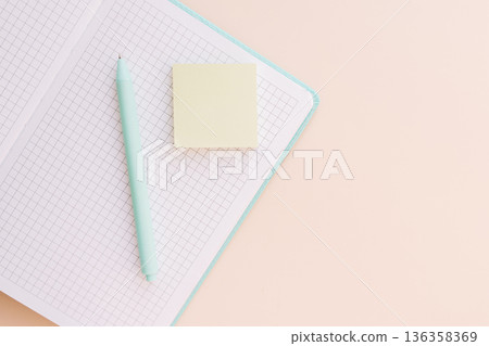 Mint pen and sticky note on grid notebook with copy space, minimal flat lay Mint pen and sticky note on grid notebook with copy space, minimal flat lay 136358369