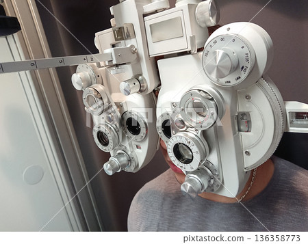 Vision test closeup on phoropter in clinic, vision measurement guides prescription, vision screening healthcare, patient education, medical training concept 136358773
