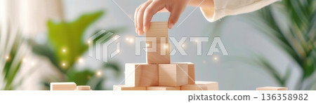 Hands of a child carefully stacking wooden blocks, representing learning and development Hands of a child carefully stacking wooden blocks, representing learning and development 136358982