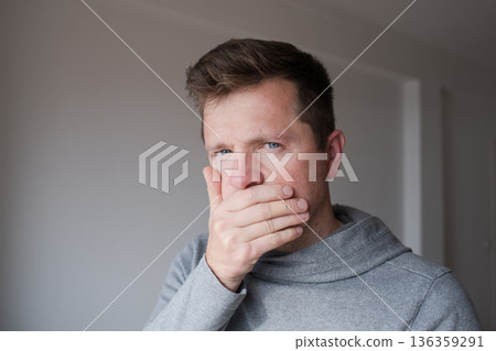 Man covering his mouth with hand trying to keep a secret and stay silent Man covering his mouth with hand trying to keep a secret and stay silent 136359291