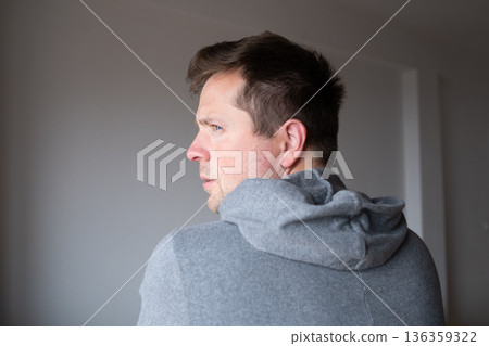 Offended man turning his back and looking back over his shoulder with resentment Offended man turning his back and looking back over his shoulder with resentment 136359322