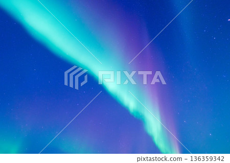 Stunning aurora borealis glowing in the dark night sky filled with bright stars.  136359342