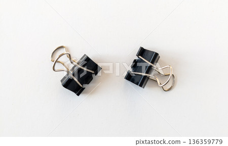Paper clips isolated on a white background. Black binder clips, a simple yet versatile office tool for business and management 136359779
