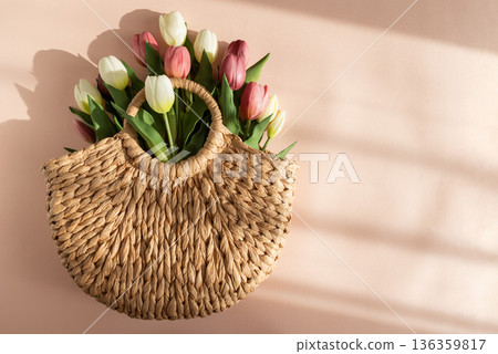 Tulip Bouquet in Straw Handbag.  Stylish Spring Floral Composition on Pink Background 136359817